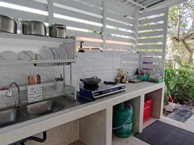 The covered outdoor kitchen with a gas burner and double sink