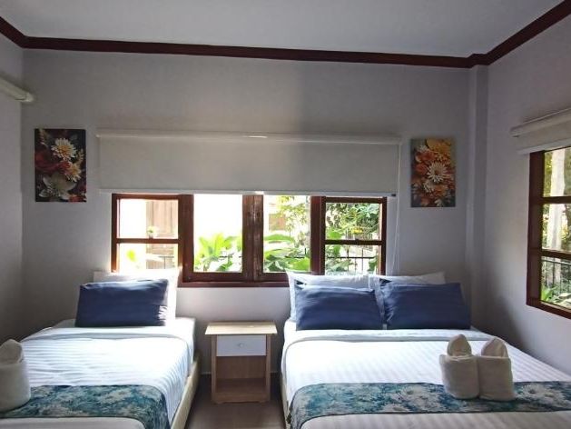 A bedroom with two single beds and a leafy outlook