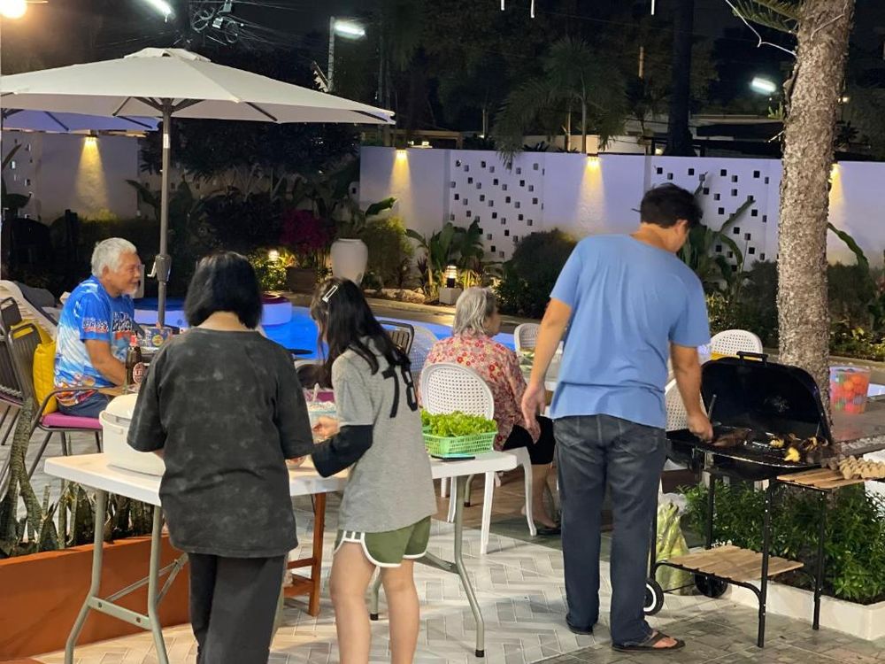Guests gathered around tables by the pool in the evening