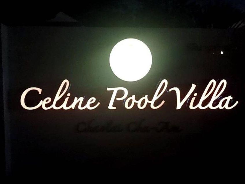 The illuminated Celine Pool Villa sign at night
